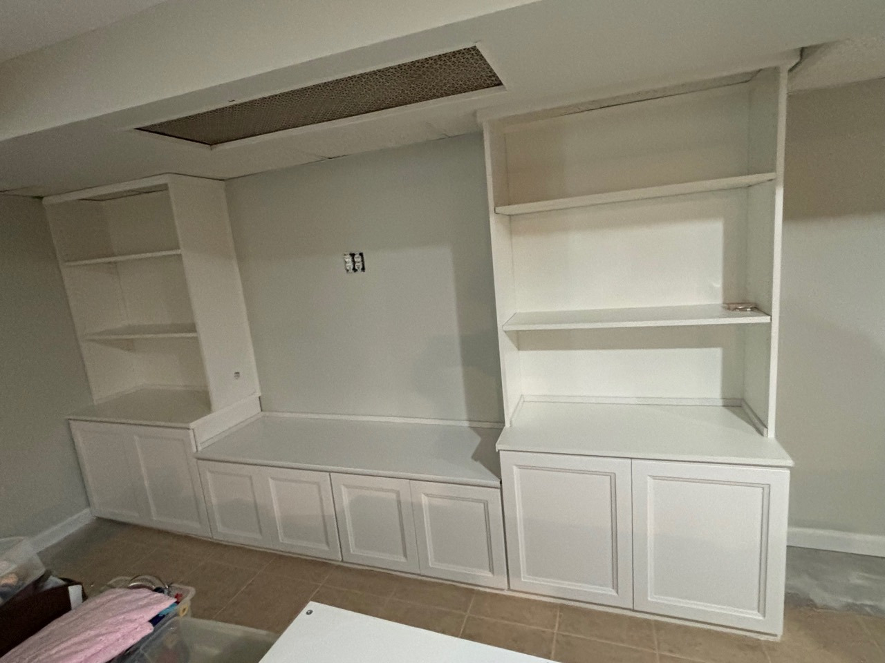 White built-in base cabinets and open display shelving along an interior wall